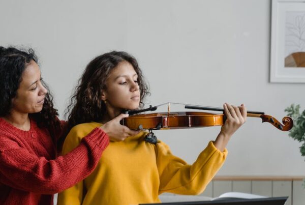 Girl being sized for violin, positioning of violin, teaching violin, Choosing the Right Size String Instrument