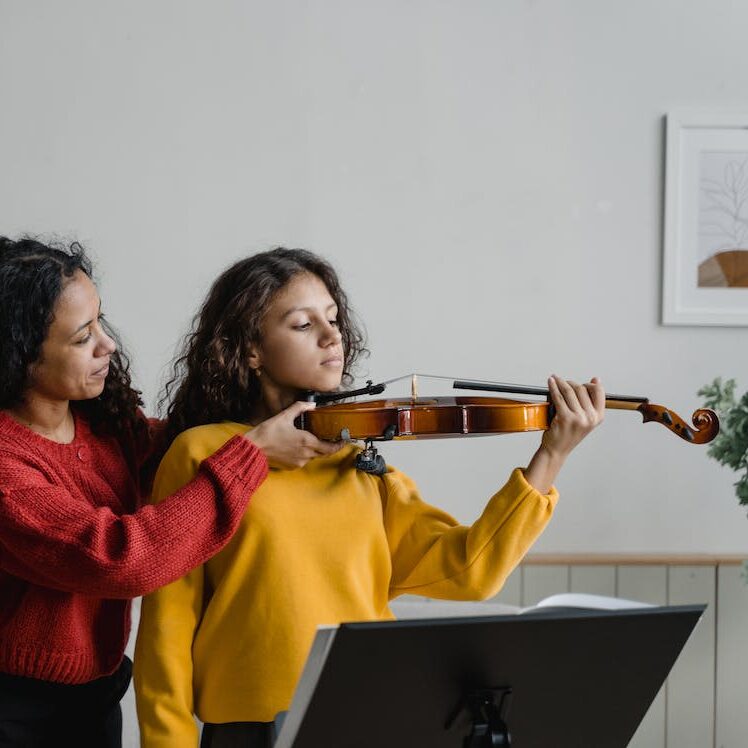 Girl being sized for violin, positioning of violin, teaching violin, Choosing the Right Size String Instrument