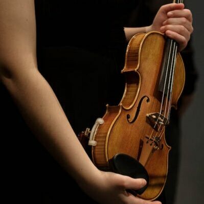 Girl holds violin, violin bridge, refitting fallen bridge